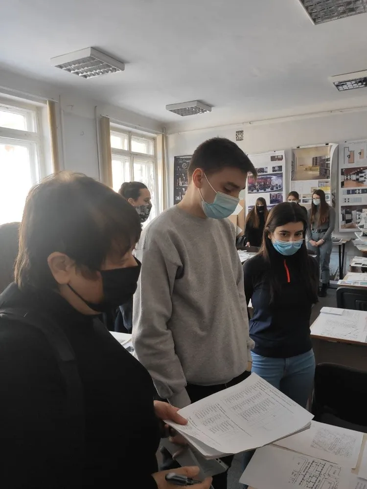 Students reviewing design drawings in a classroom