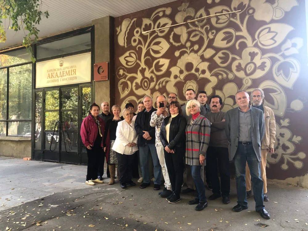 A group outside a building with decorative artwork