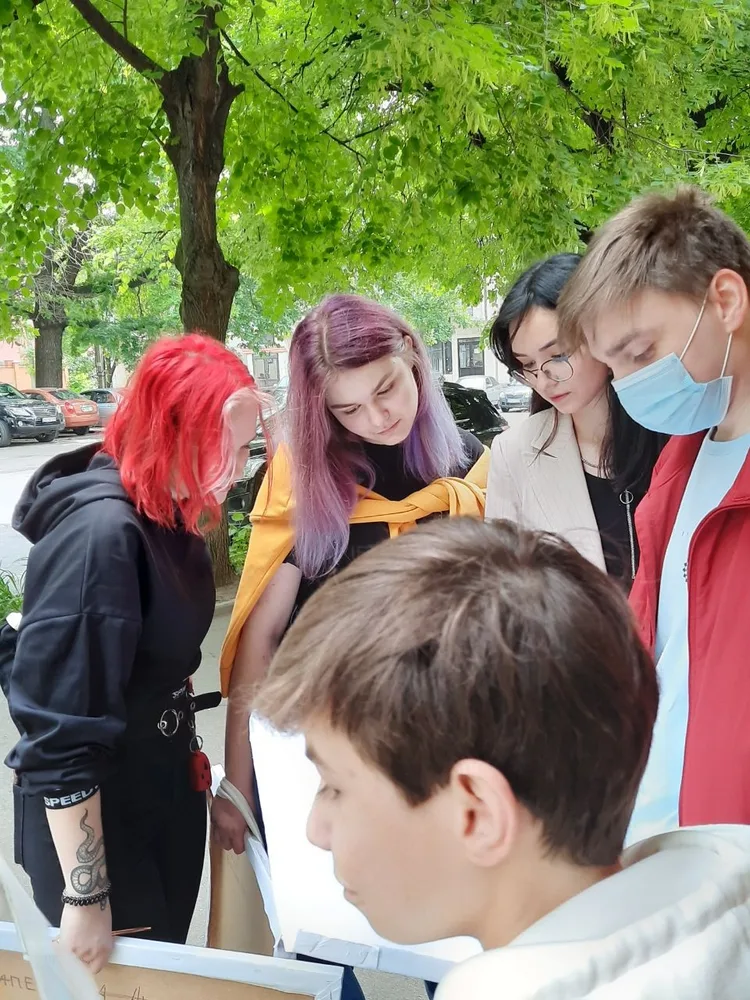 Students discussing drawings outdoors