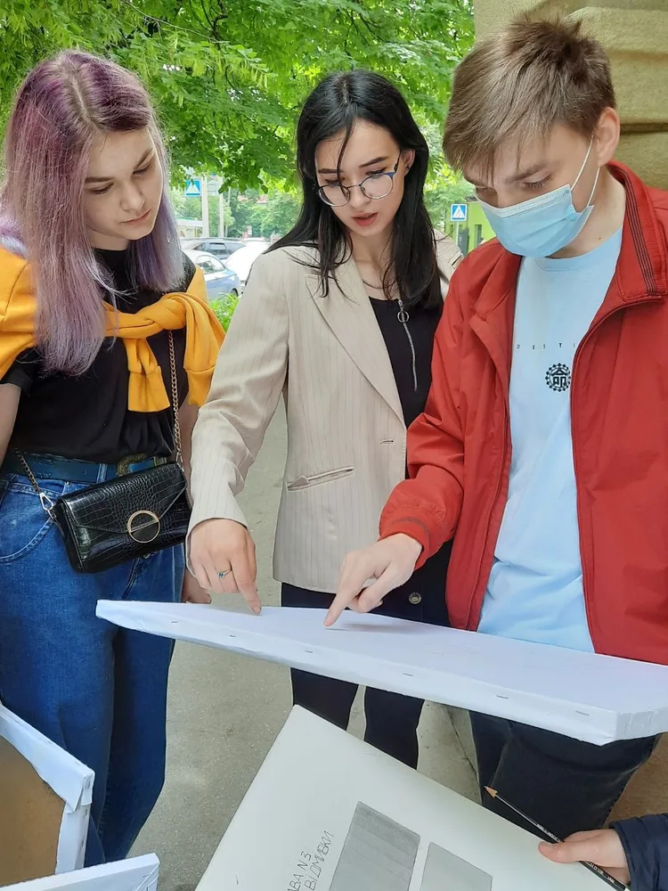 Students gathered around architectural drawings