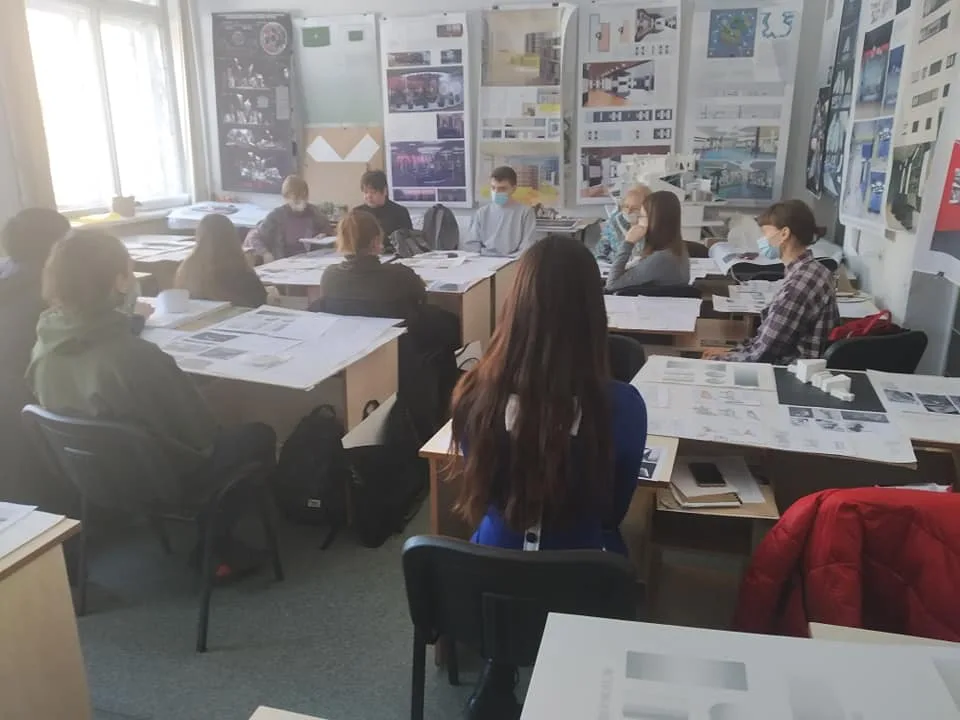 Students working on architectural drawings in a classroom